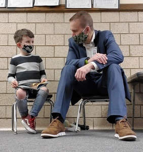 Boy reading to superintendent